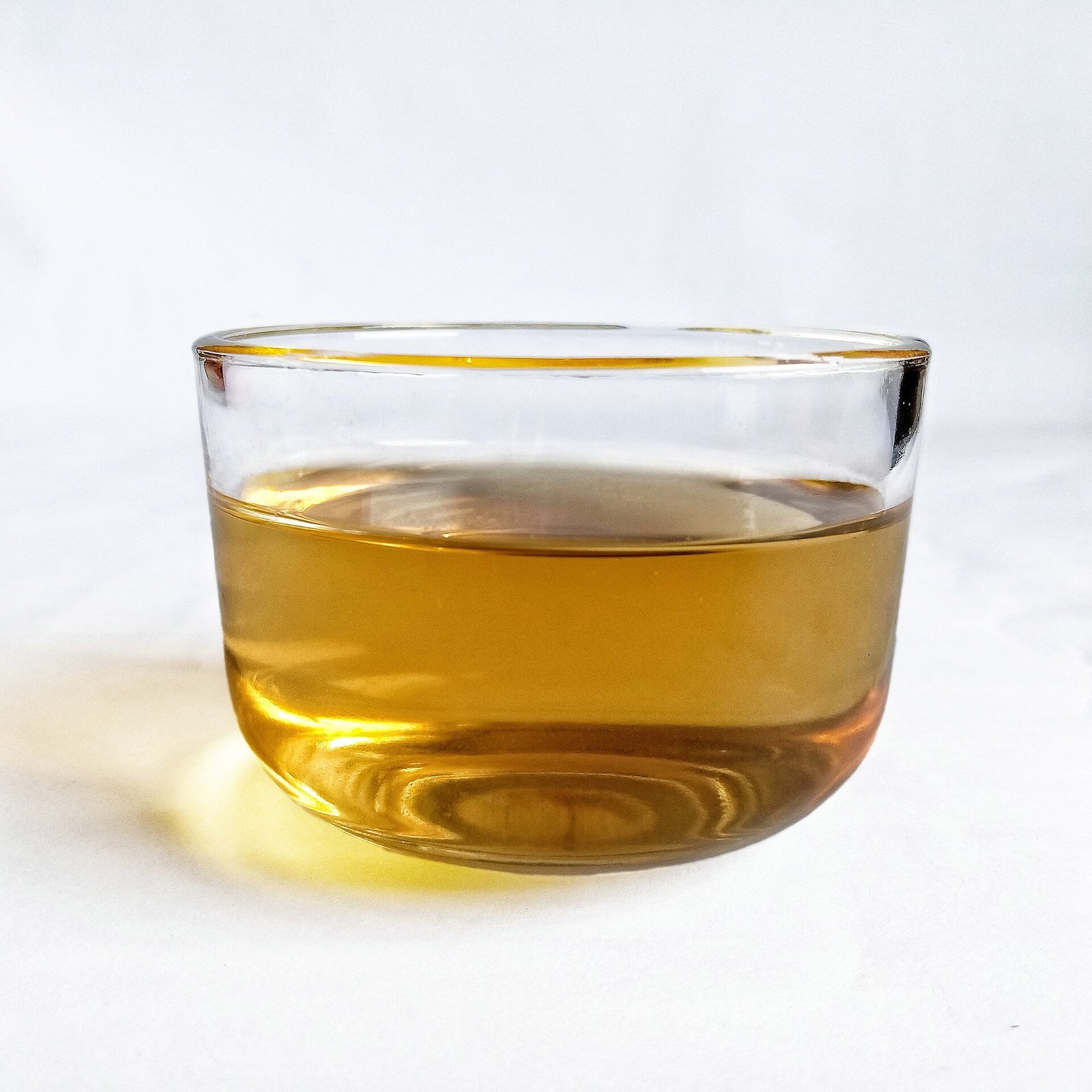 A clear glass cup of golden herbal tea